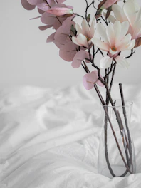 Vibrant mixed floral bouquet with deep reds and soft pinks in a minimalist setting.