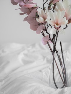 A serene bouquet of bleached flowers and pampas grass resting on a beige linen cloth, highlighting texture and calm luxury