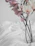 A delicate pastel pink silk flower arrangement on a minimalist white table.
