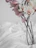 A delicate pastel pink silk flower arrangement on a minimalist white table.
