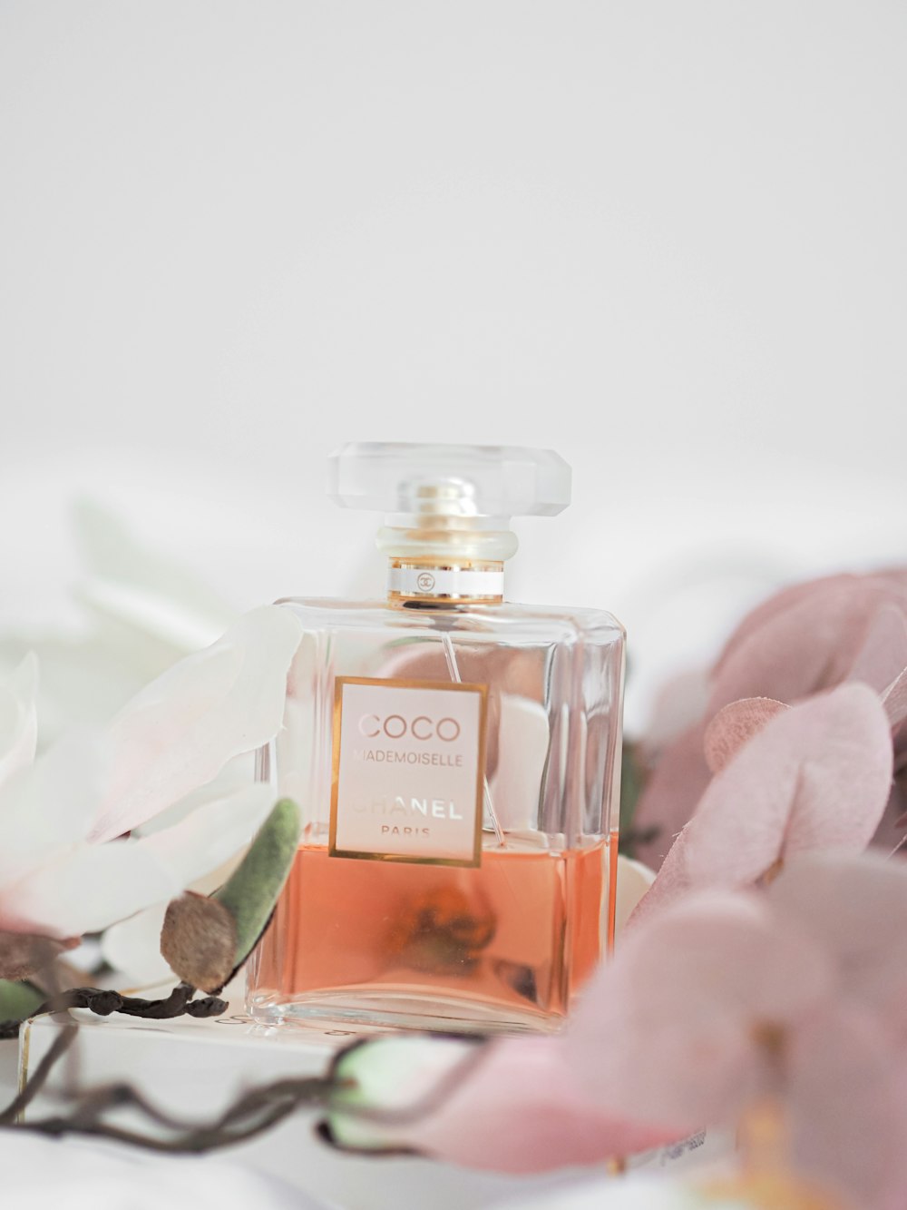 clear glass perfume bottle on pink rose