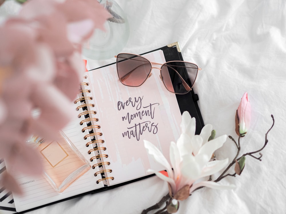 black framed sunglasses on white notebook