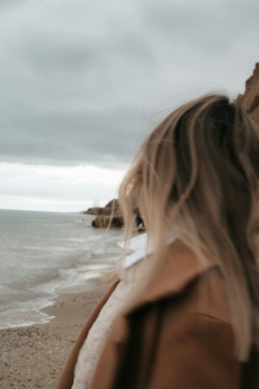 woman in white shirt standing on beach during daytime