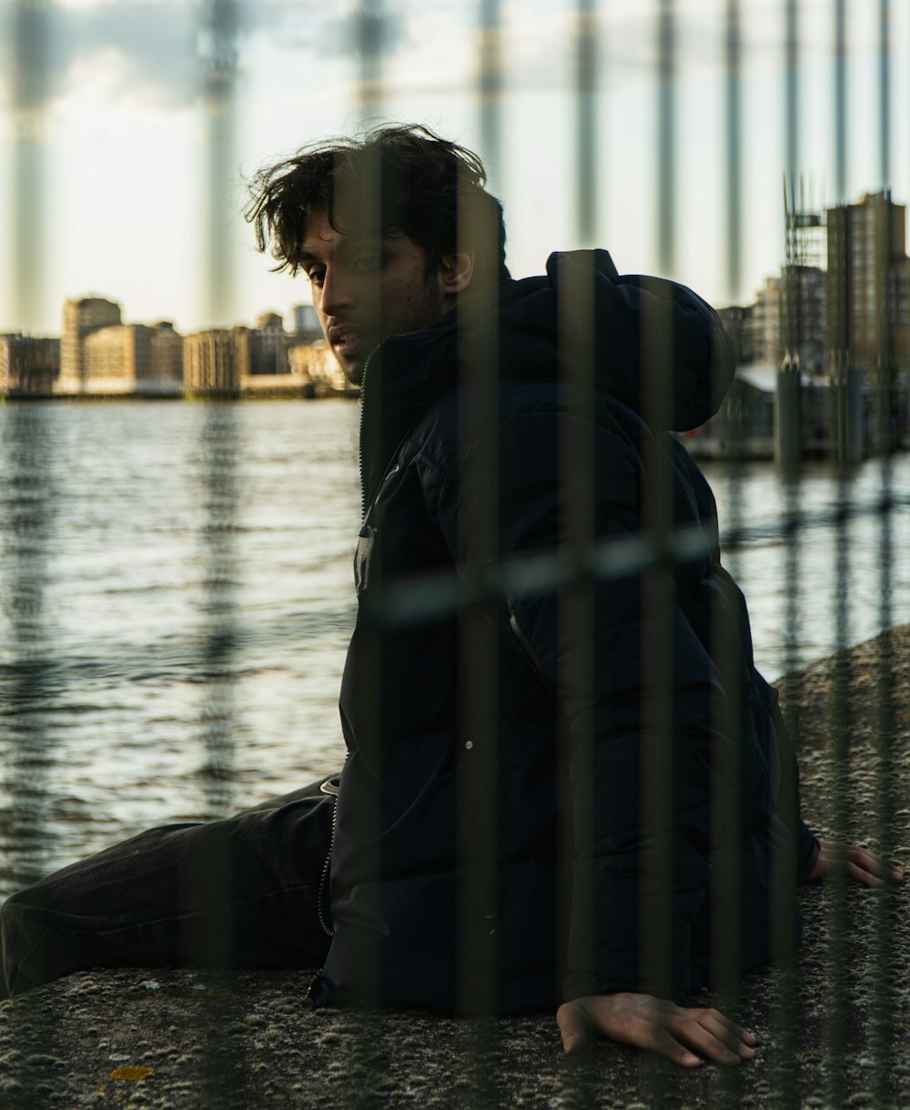 man in black jacket standing near body of water during daytime