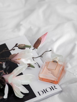 Close-up of Dior perfume with floral background and gentle sunlight