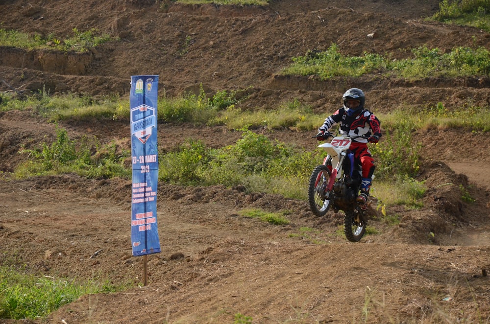 man in red and black motocross helmet riding motocross dirt bike