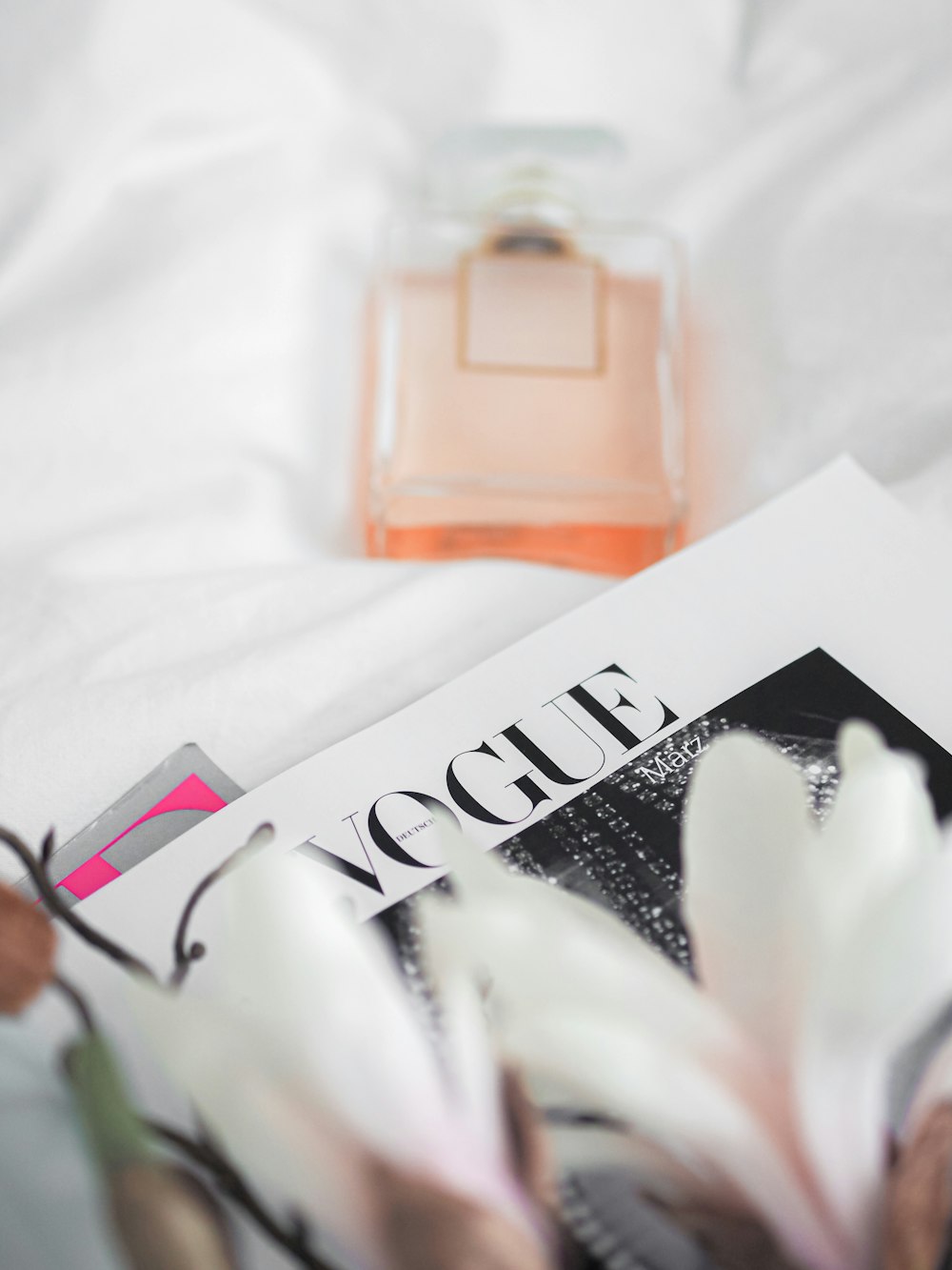 pink perfume bottle on white textile