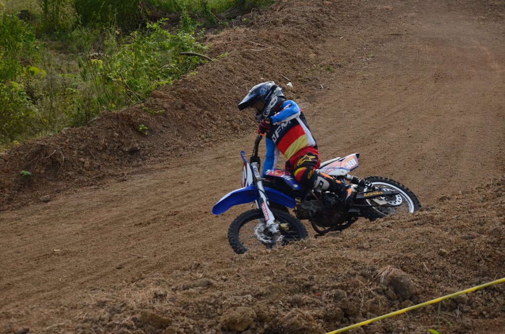 man in white and red dirt bike racing on dirt road during daytime