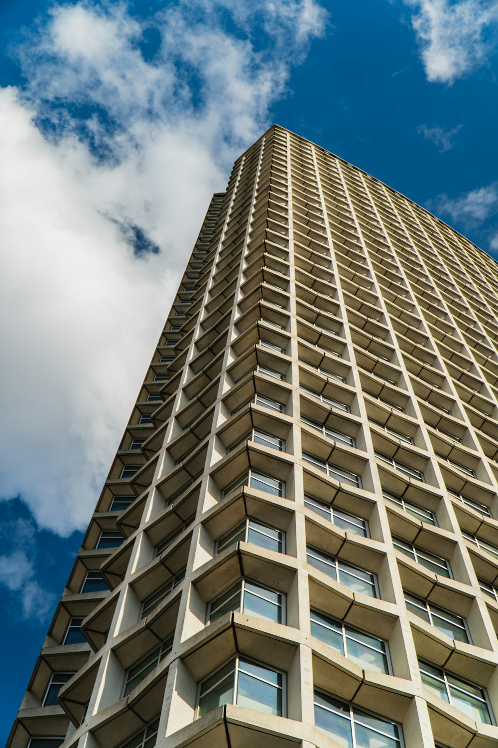 low angle photography of brown concrete building under blue sky during daytime