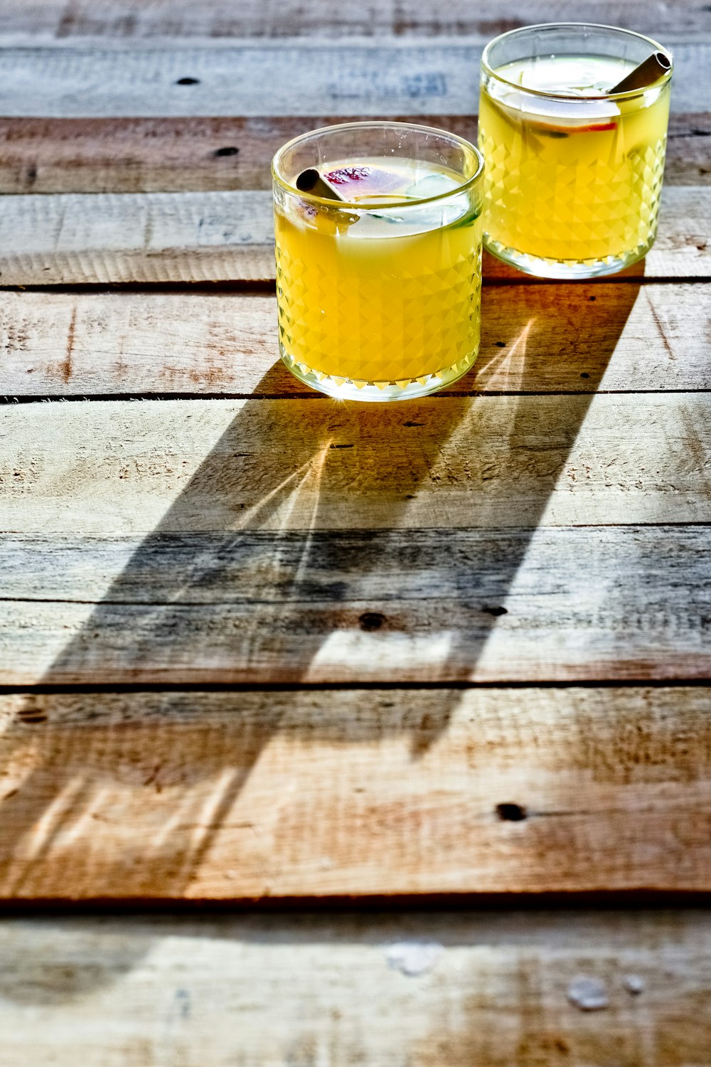 2 clear drinking glasses on brown wooden table