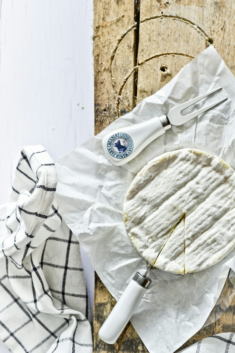 Placa redonda de cerámica blanca y azul junto a tenedor de acero inoxidable sobre textil blanco