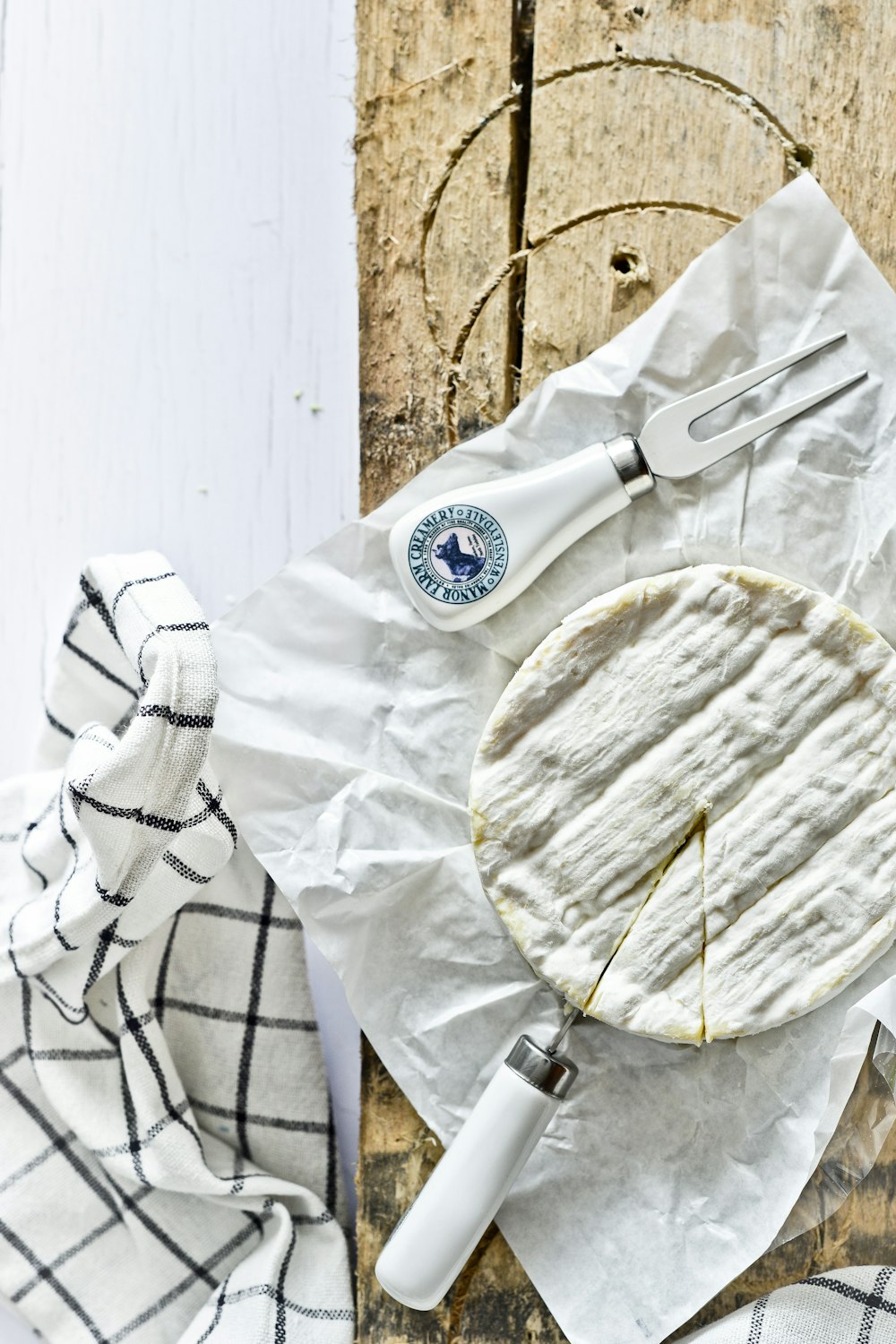 white and blue ceramic round plate beside stainless steel fork on white textile