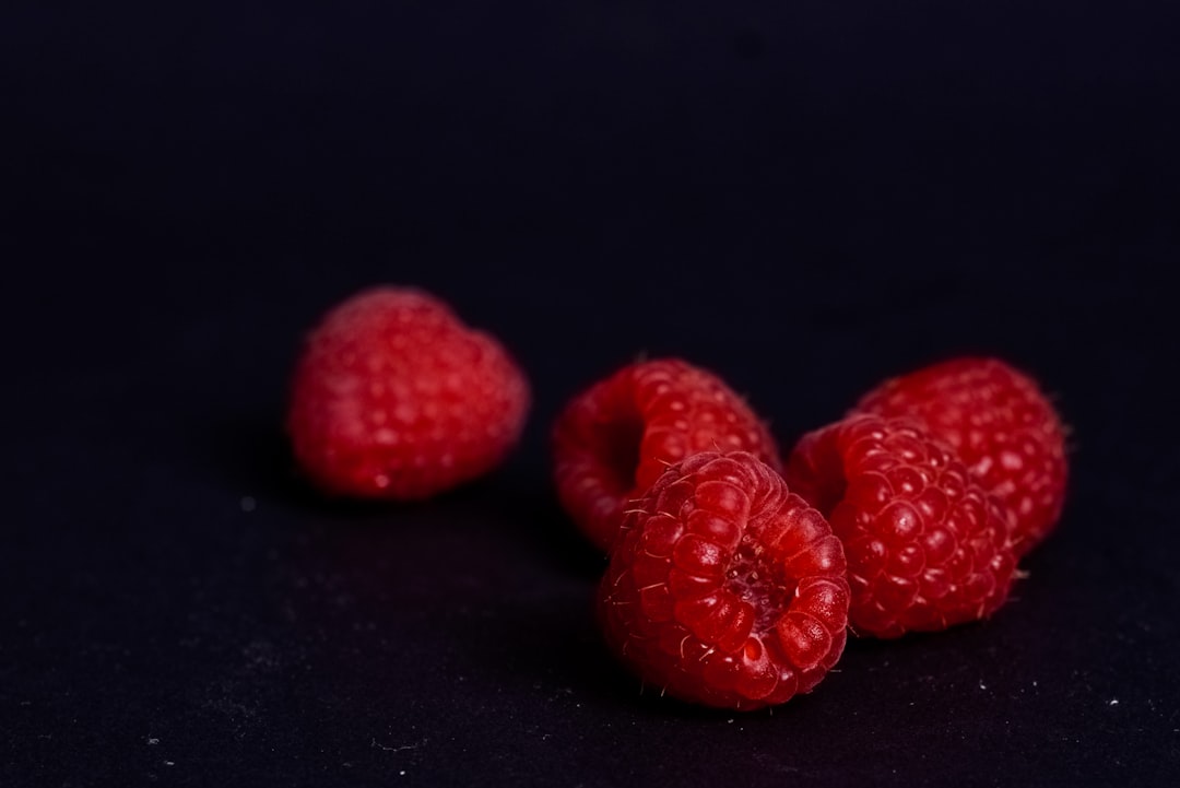 red strawberries on black surface,
