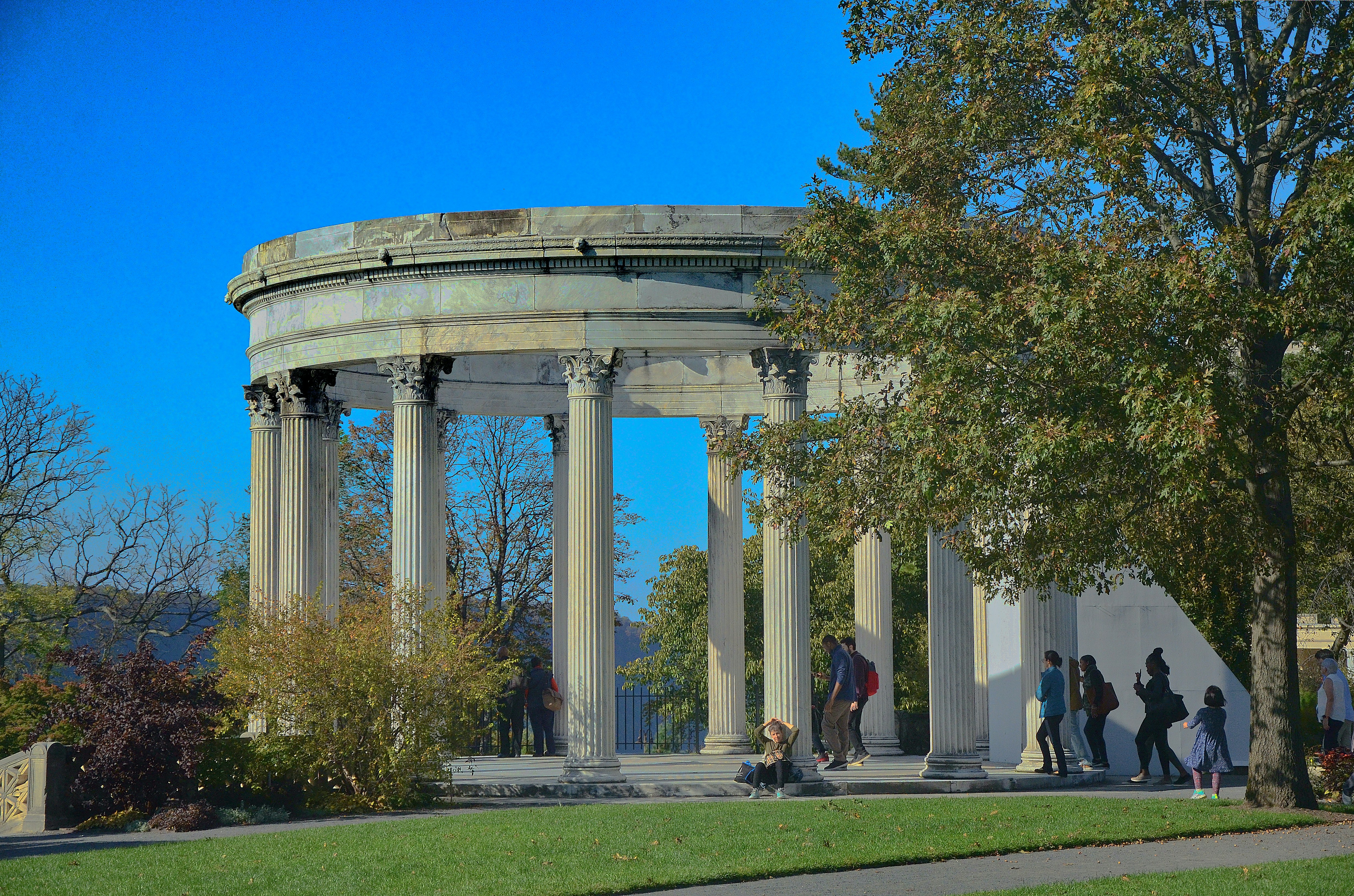 people walking on green grass field near white concrete building during daytime