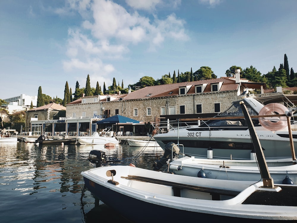 Bateau blanc et noir sur l’eau près d’un bâtiment en béton brun pendant la journée