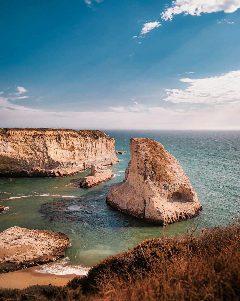 brown rock formation on body of water during daytime