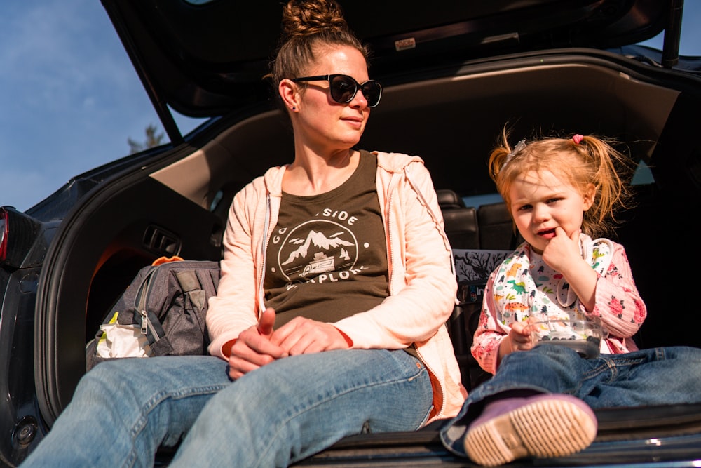 woman in black crew neck t-shirt and blue denim jeans sitting on car seat