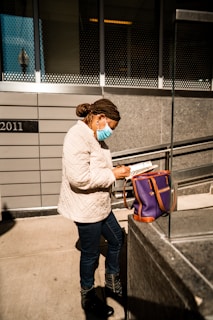 A candid shot of Minah Kang engaged in field research, notebook in hand, amidst a vibrant urban landscape.