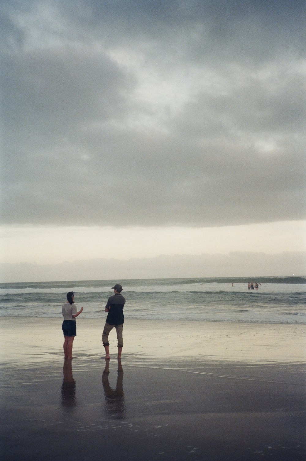 man and woman walking on beach during daytime