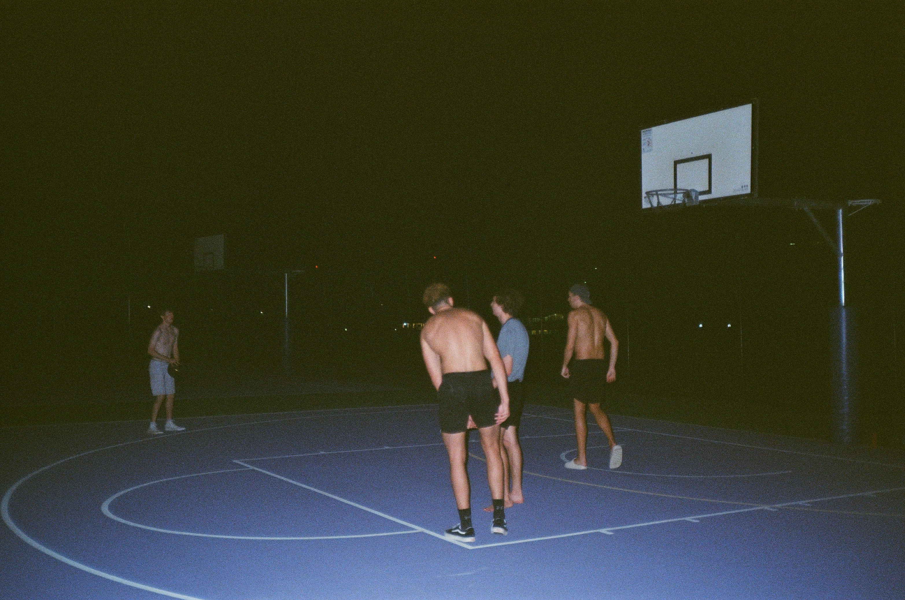 man in black shorts standing on a basketball court