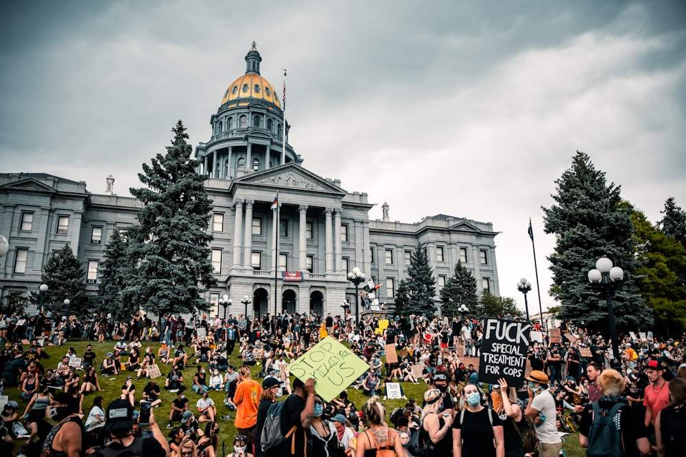 people gathering in front of white concrete building during daytime