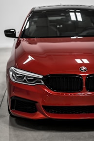 Close-up of a shiny silver sedan's front grille with city lights reflecting.