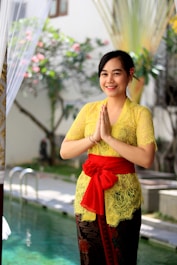 woman in yellow and red floral dress holding umbrella