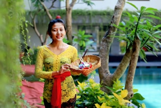 woman in yellow floral dress holding clear glass bowl with fruits
