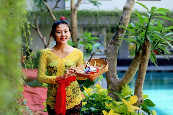 woman in yellow floral dress holding clear glass bowl with fruits in Seminyak
