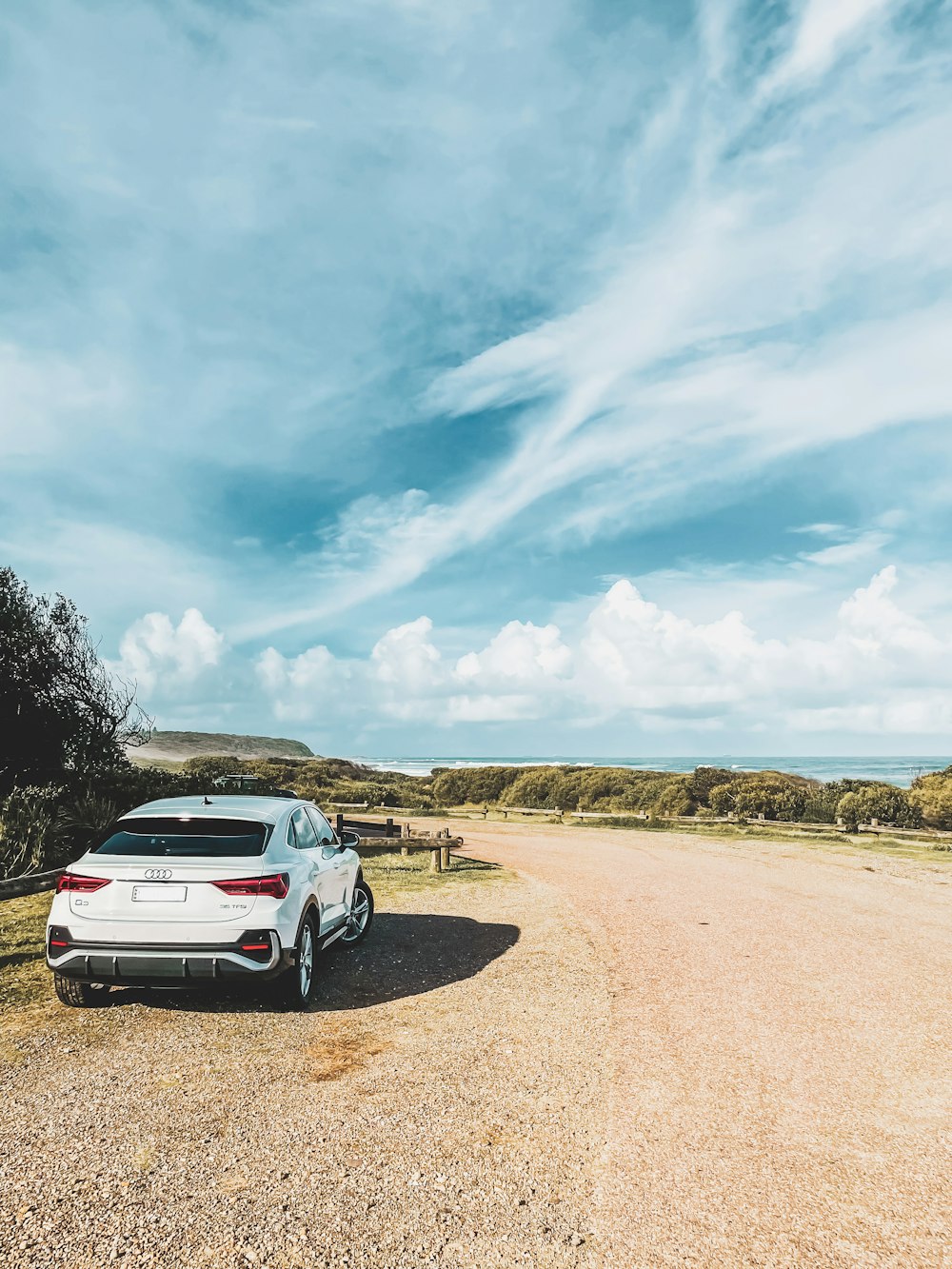 white suv on brown sand under blue sky during daytime