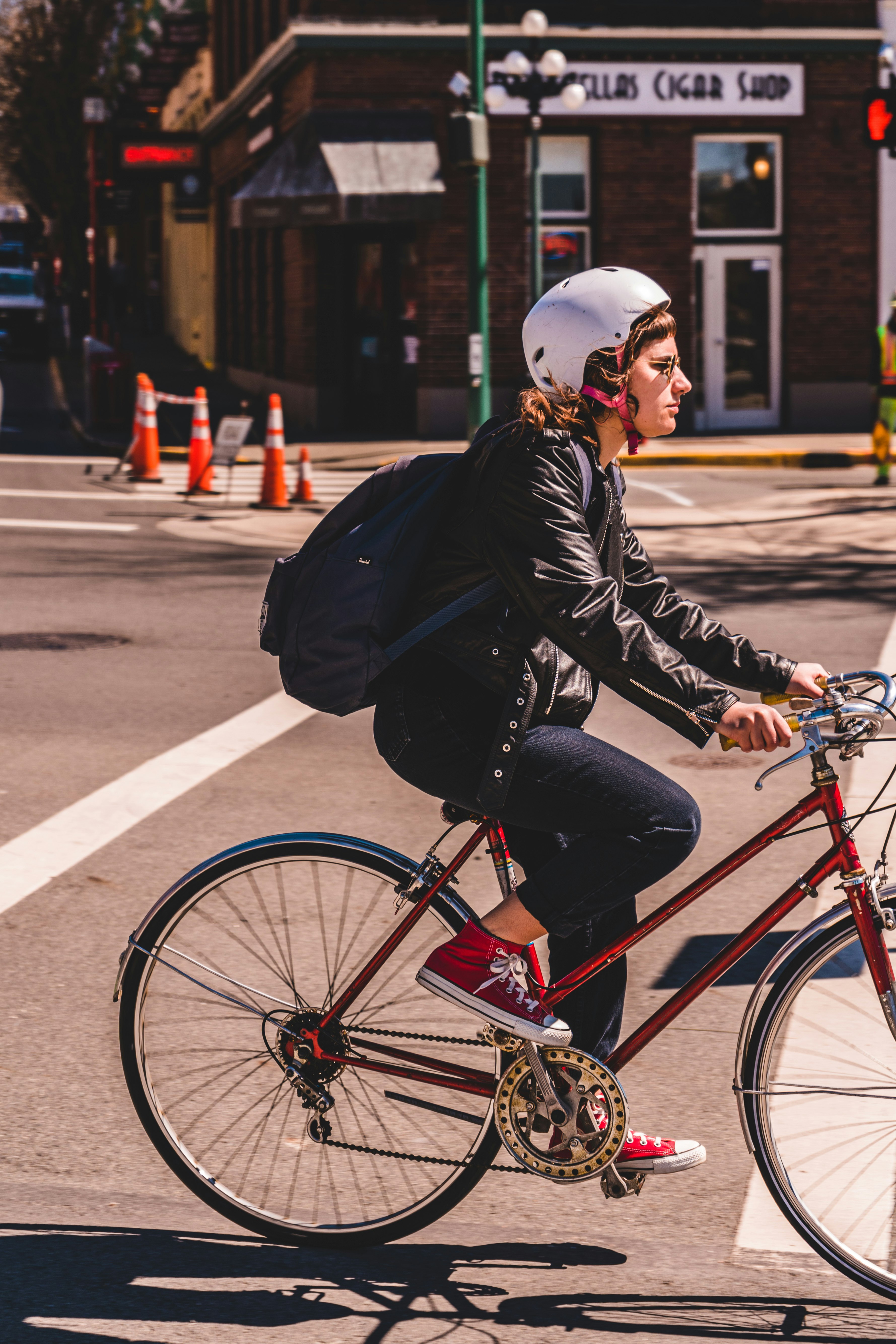 man in black jacket riding red bicycle on road during daytime