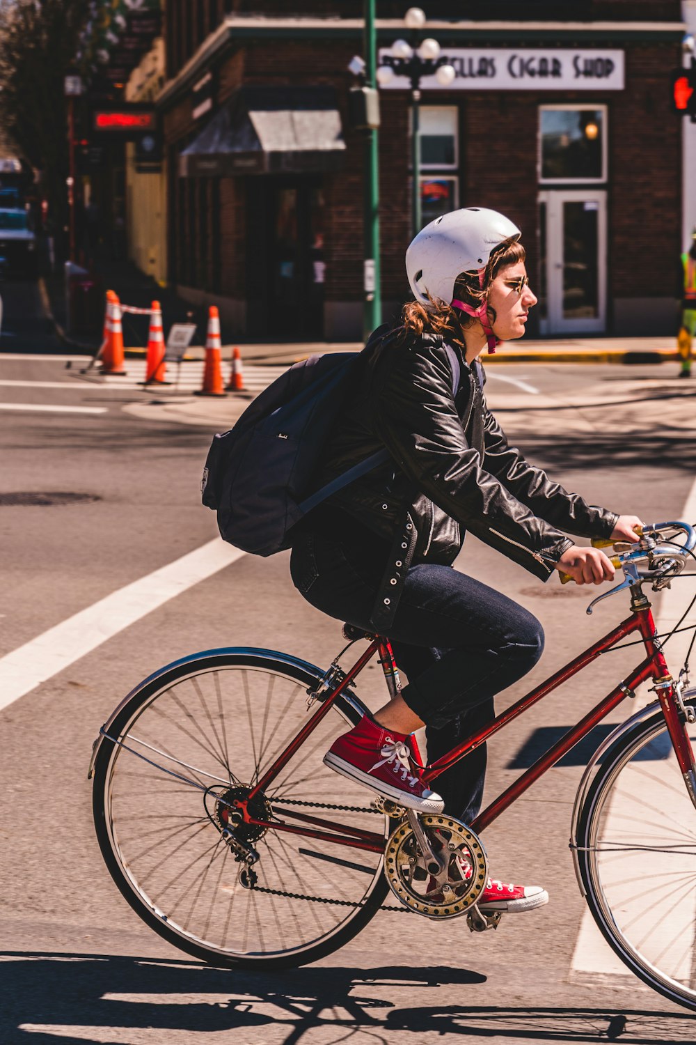 man in black jacket riding red bicycle on road during daytime