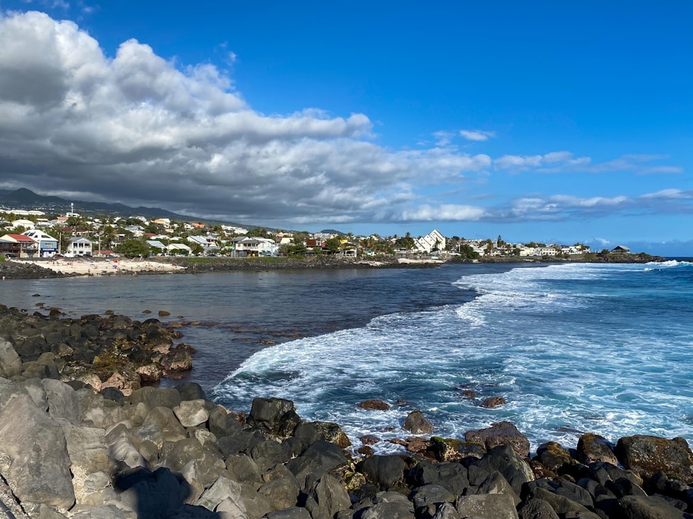 rocky shore under blue sky and white clouds during daytime