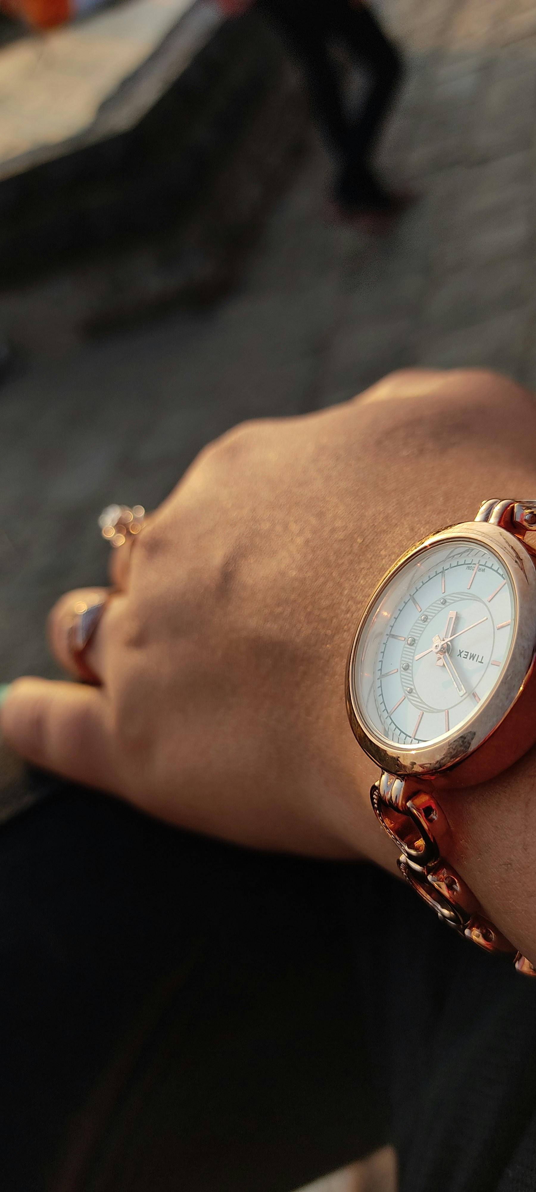 Woman showing off gold rings on fingers, elegant hand pose, warm ambient lighting
