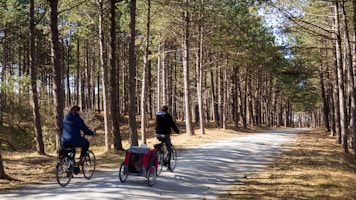man in blue jacket riding on bicycle on road during daytime