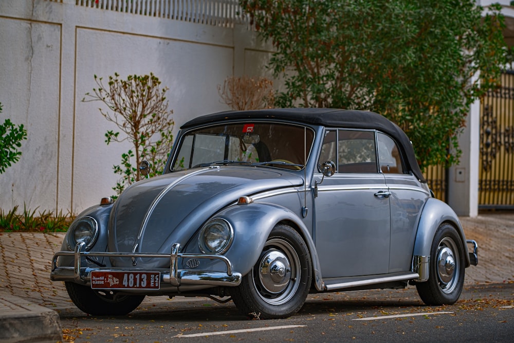 blue classic car parked near white building