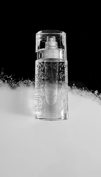 High-resolution image of a perfume bottle with subtle reflections on a white surface.
