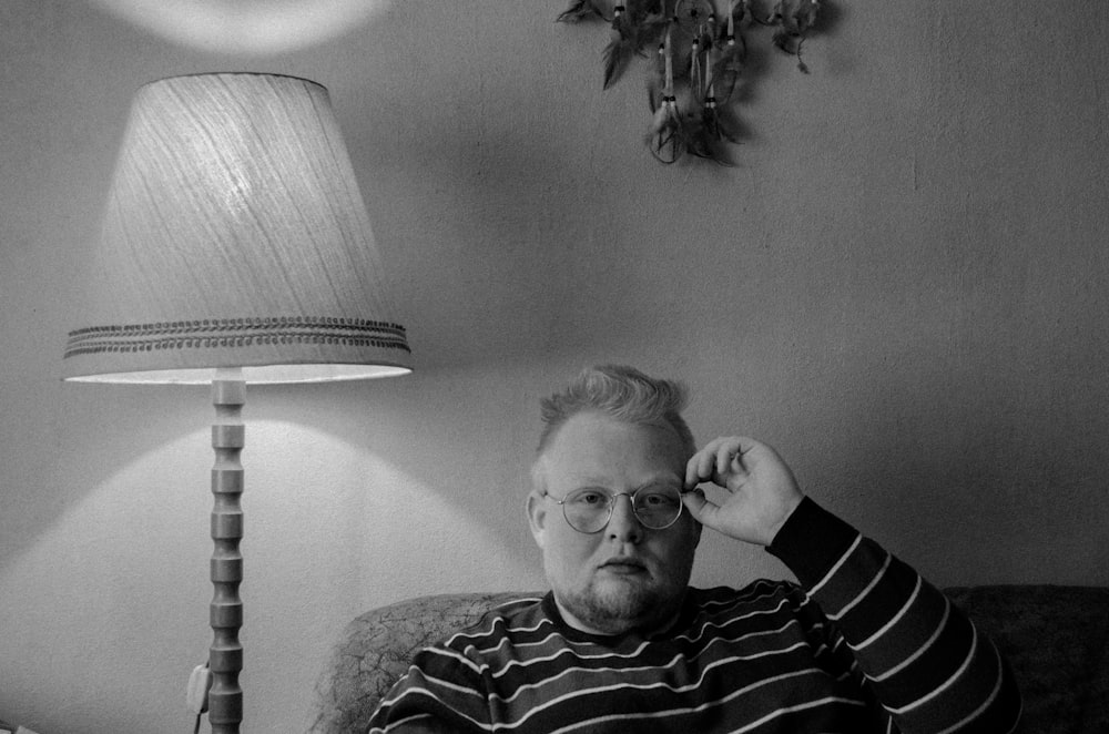 man in black and white striped sweater sitting on sofa