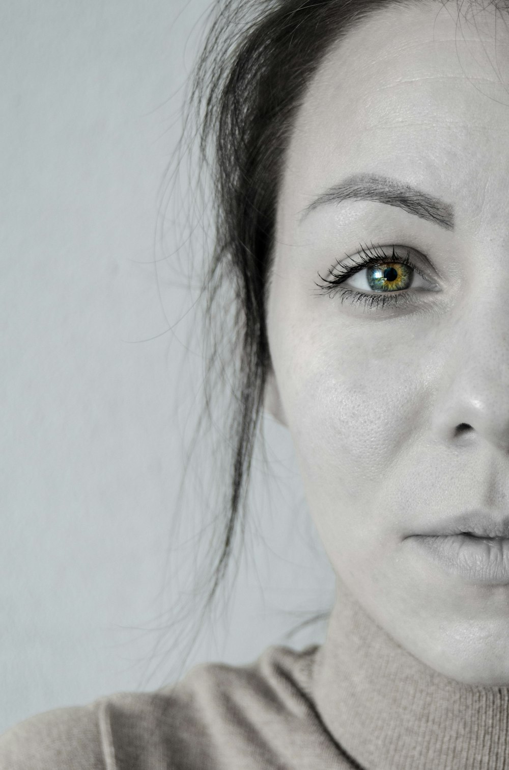 woman with black hair and white wall