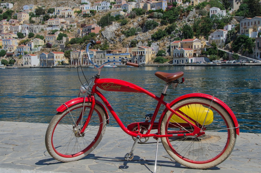 red city bike near body of water during daytime