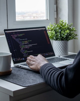 person using macbook pro on table