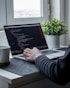 person using macbook pro on table