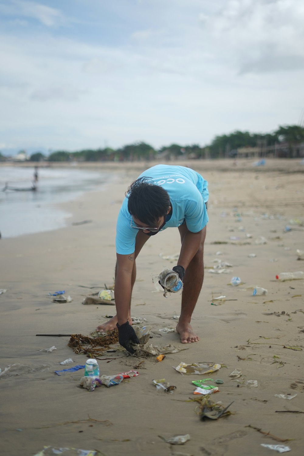 man in blue t-shirt and blue shorts playing soccer on beach during daytime