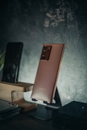 An elegant mobile device showing a seamless user interface in muted bronze tones.