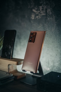 A sleek smartphone displayed on a wooden table with comparison charts in the background