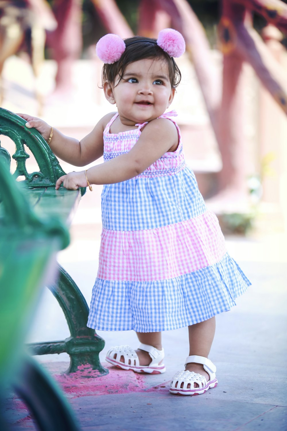 girl in blue and white polka dot dress standing on playground during daytime