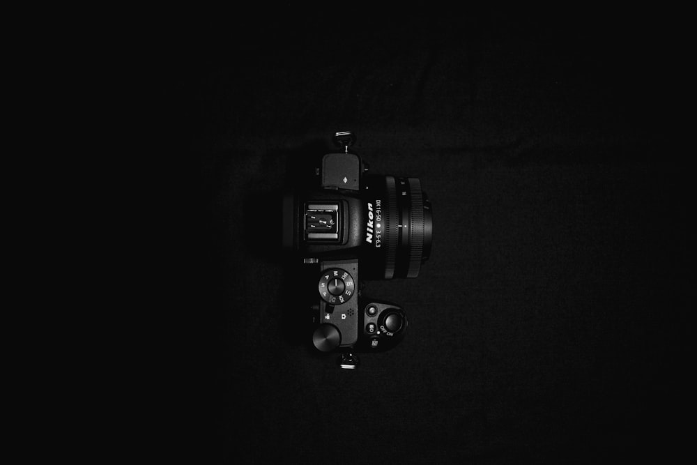 black dslr camera on black textile