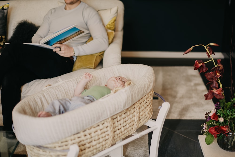 baby in yellow long sleeved shirt lying on white wicker bed