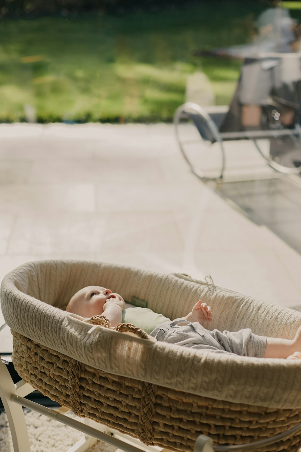 bébé en chemise blanche couché sur un panier en osier marron