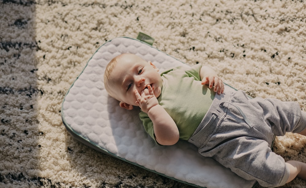 boy in green t-shirt lying on white and blue hammock